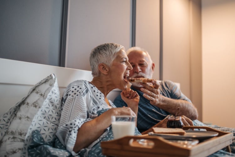 Getty-Images-old-couple-eating-bread-in-bed-bernardbodo.jpg