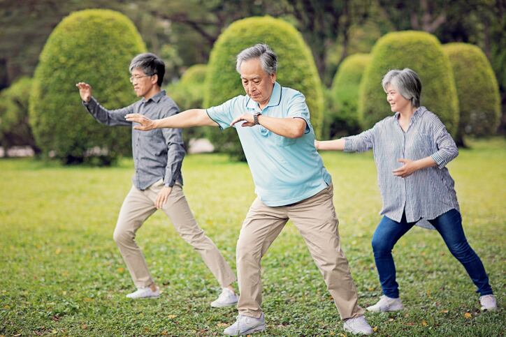 A group of seniors practicing Tai Chi in the park.