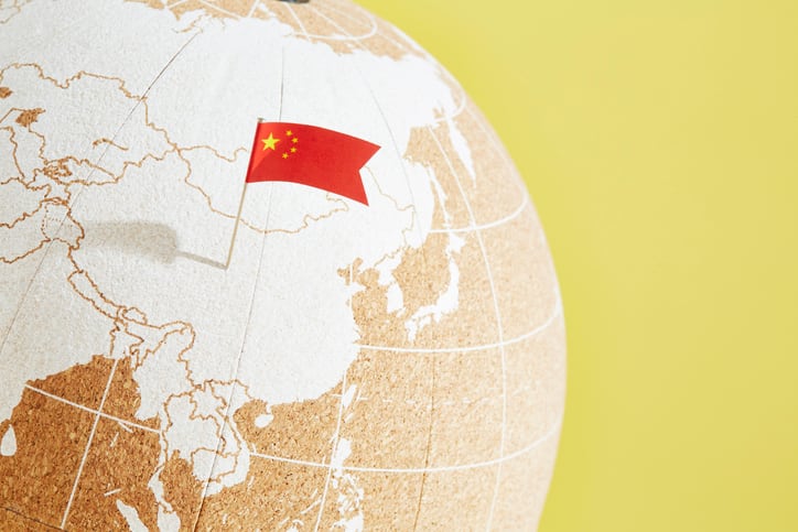 A picture showing the flag of China pinned on the part of a globe showing Mainland China.