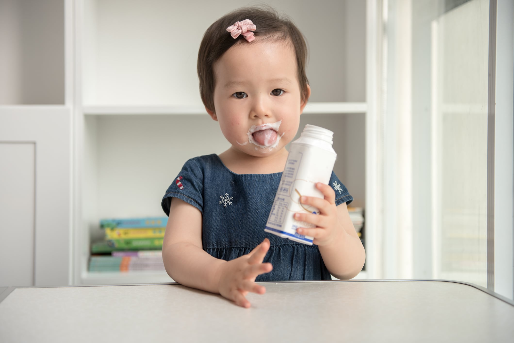 Little girl drinking milk or yogurt